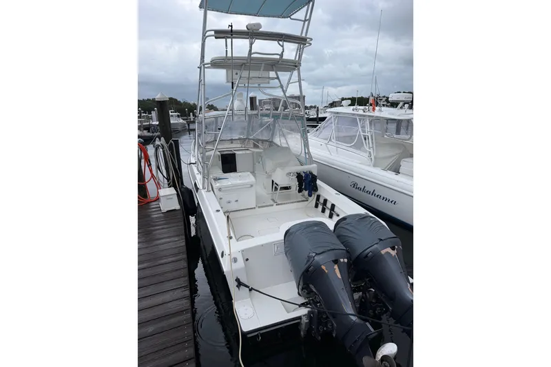 Slide: The Image of 2002 Contender 35 Express Side Console boat docked with twin engines. - 3