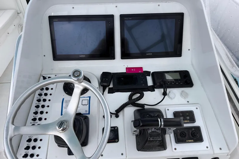 Slide: The Image of 2002 Contender 35 Express Side Console dashboard with Garmin displays and steering wheel. - 4