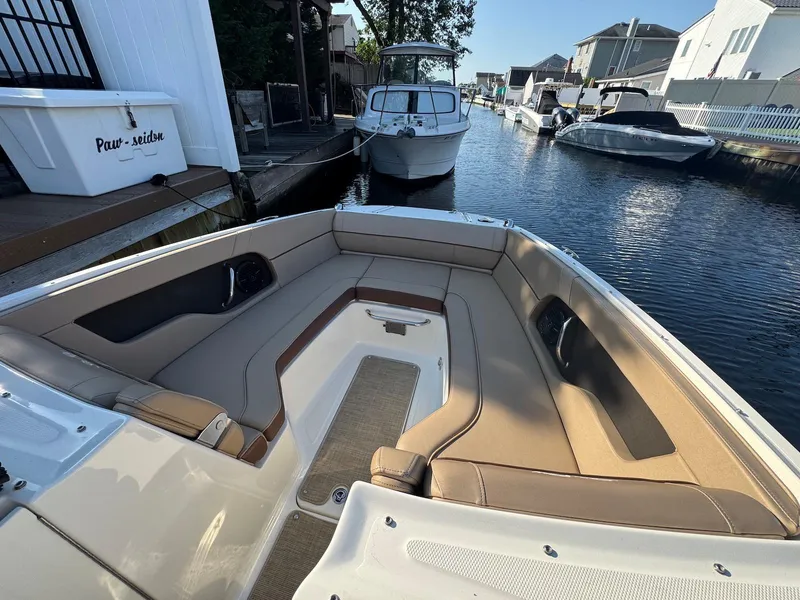Slide: The Image of 2017 Sea Ray SDX 240 boat interior with beige seating, docked in a canal. - 12