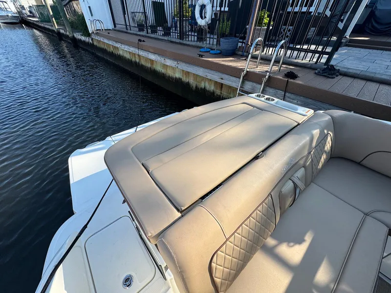 Slide: The Image of 2017 Sea Ray SDX 240 boat with beige seating, docked by a waterfront. - 13