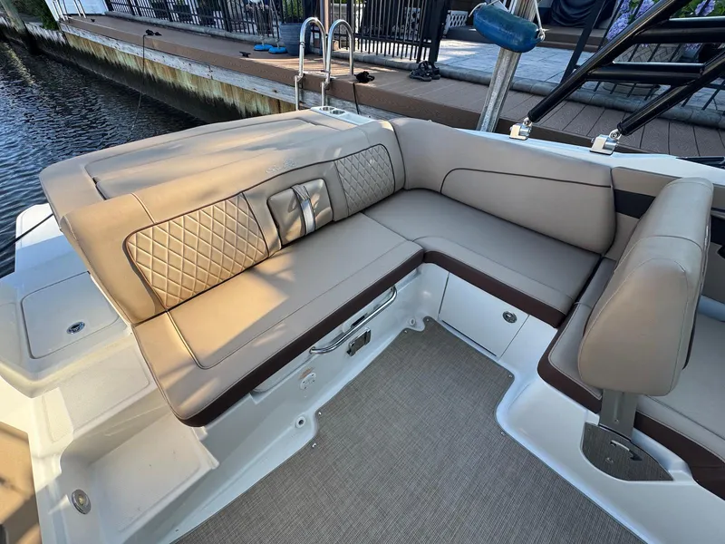 Slide: The Image of 2017 Sea Ray SDX 240 boat interior with beige cushioned seating and quilted design. - 15