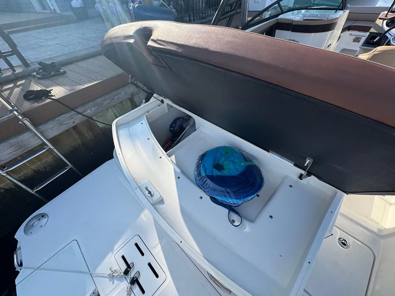 Slide: The Image of 2017 Sea Ray SDX 240 boat with open storage compartment at dockside. - 17