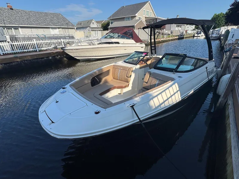 Slide: The Image of 2017 Sea Ray SDX 240 boat docked in a residential canal. - 2