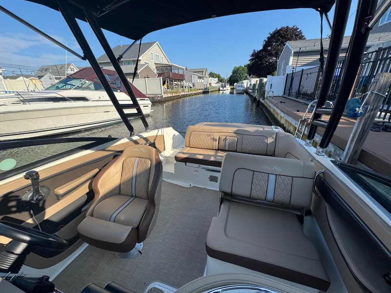 Slide: The Image of 2017 Sea Ray SDX 240 boat interior with tan seating, docked in a canal. - 7