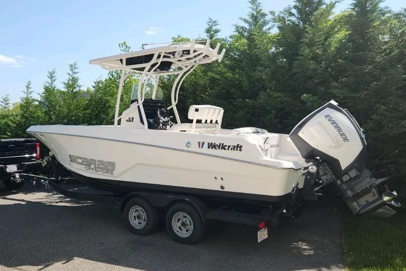 The Image of 2019 Wellcraft 222 Fisherman boat on trailer, parked near lush greenery. - 1