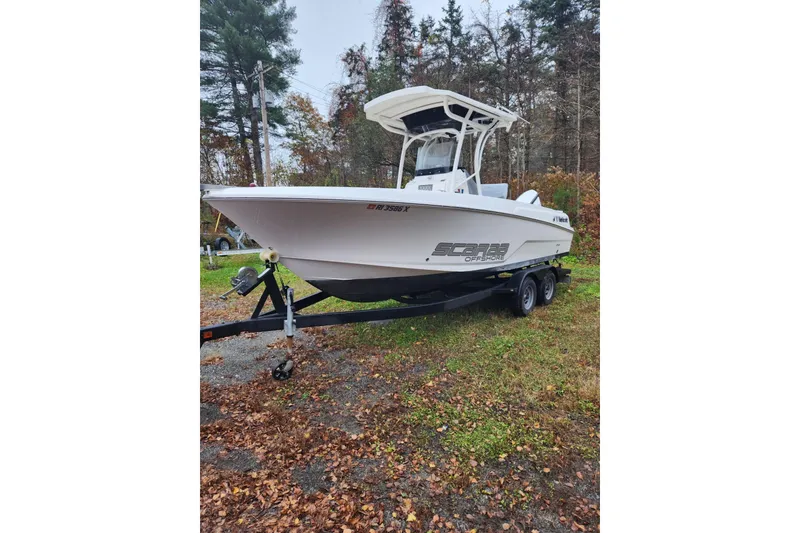 Slide: The Image of 2019 Wellcraft 222 Fisherman boat on trailer, parked outdoors with trees in background. - 3