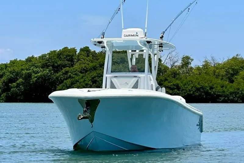 Slide: The Image of 2022 Streamline 26 boat on water, equipped with Garmin technology, surrounded by lush greenery. - 2