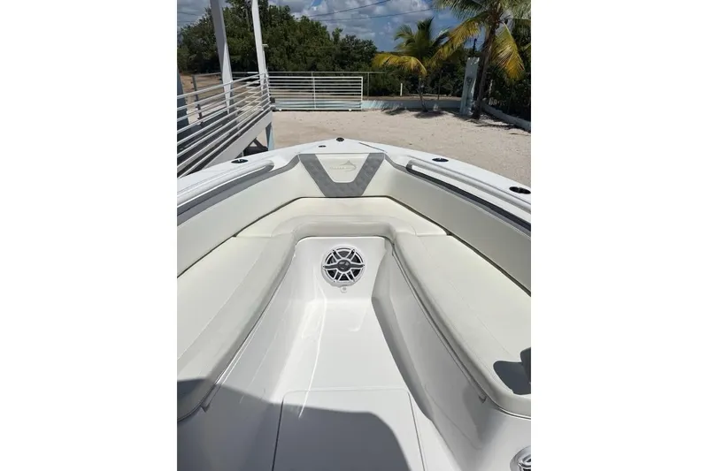 Slide: The Image of 2022 Streamline 26 boat interior with white seating and speaker, outdoor setting. - 5