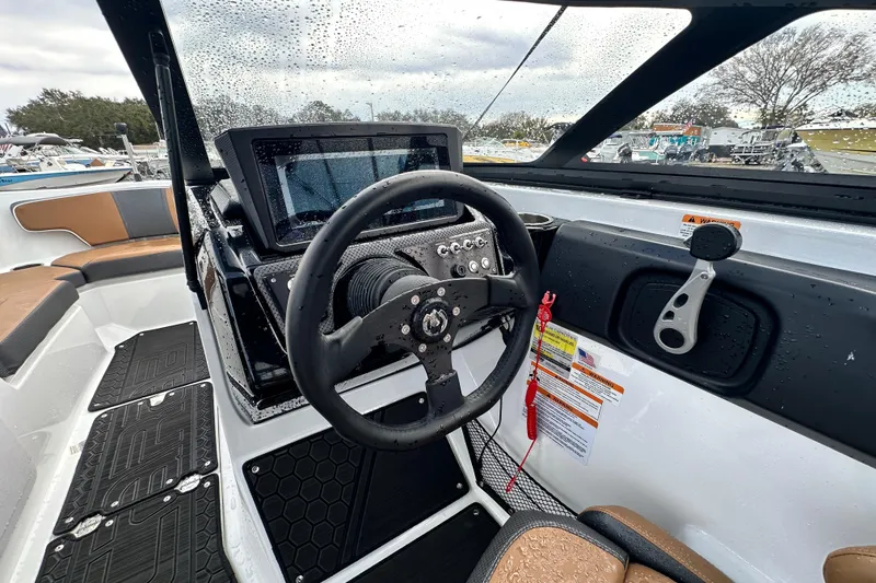 Slide: The Image of 2023 Scarab 215 ID boat interior with steering wheel and dashboard controls. - 24