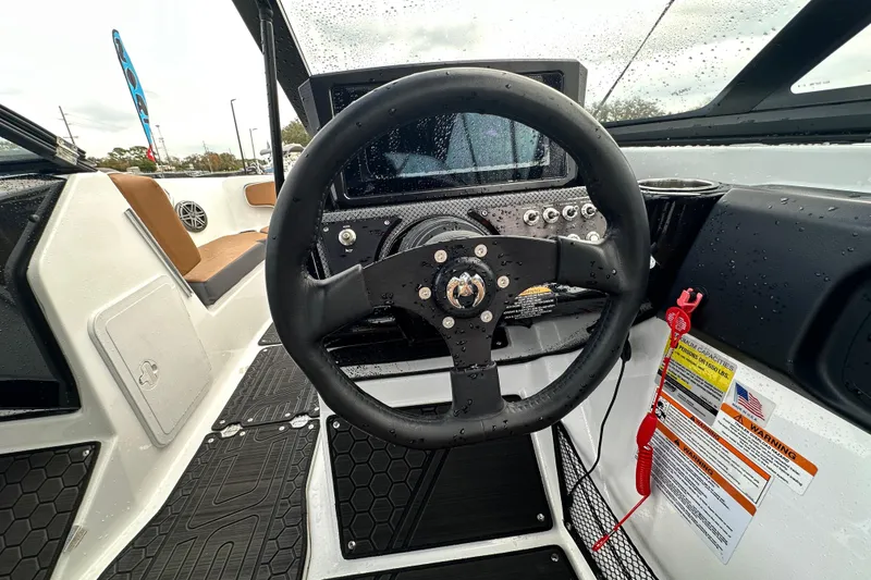 Slide: The Image of 2023 Scarab 215 ID boat cockpit with steering wheel and dashboard controls. - 25