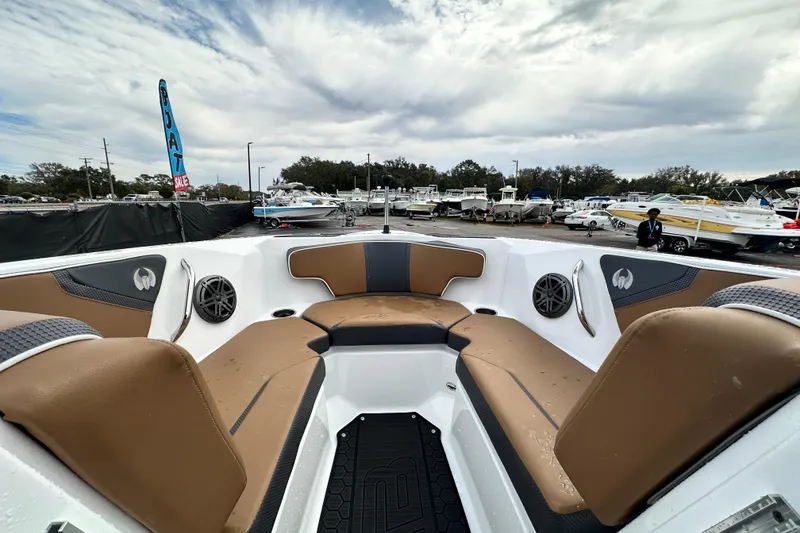 Slide: The Image of 2023 Scarab 215 ID boat interior with tan seating, displayed at a boat sale event. - 35