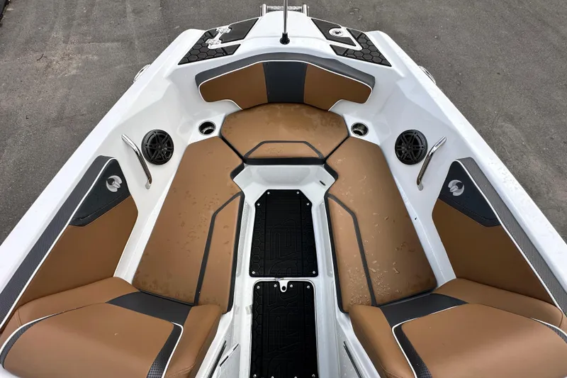 Slide: The Image of 2023 Scarab 215 ID boat interior with tan and black seating, speakers, and cup holders. - 36