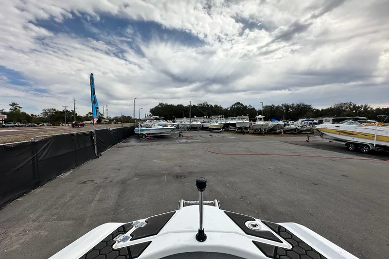Slide: The Image of 2023 Scarab 215 ID boat in a marina with multiple boats under cloudy sky. - 42
