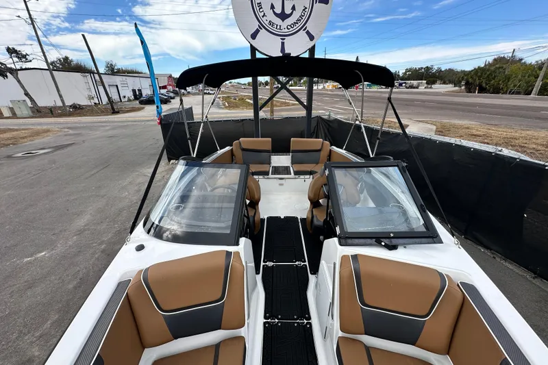 Slide: The Image of 2023 Scarab 215 ID boat with tan seating, black canopy, and sleek design. - 47