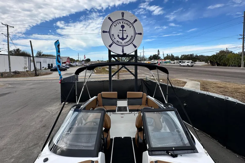 Slide: The Image of 2023 Scarab 215 ID boat displayed outdoors under a partly cloudy sky. - 48