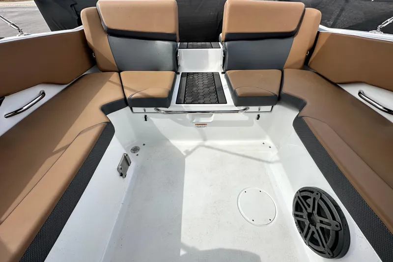 Slide: The Image of 2023 Scarab 215 ID boat interior with tan and black seating, featuring a speaker and storage area. - 60