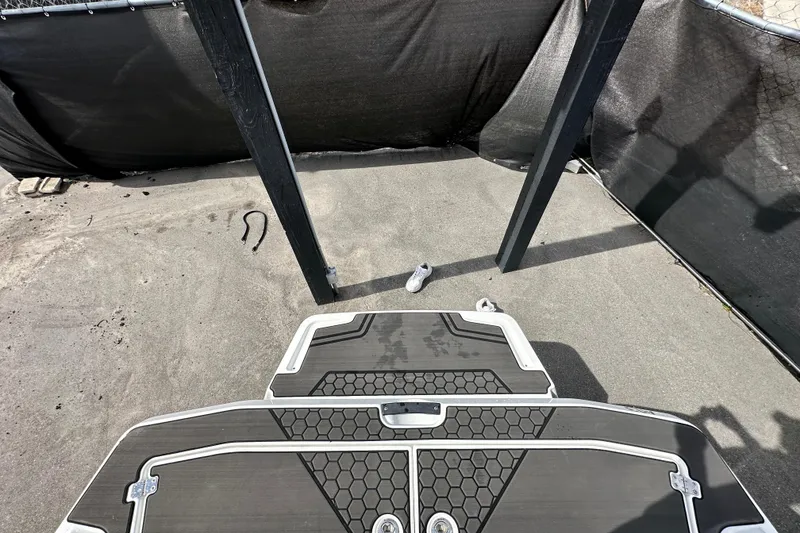 Slide: The Image of 2023 Scarab 215 ID boat deck with black non-slip surface, outdoor setting. - 67