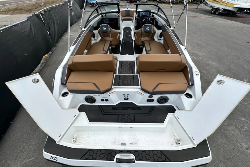 Slide: The Image of 2023 Scarab 215 ID boat with tan seating and open deck layout. - 69