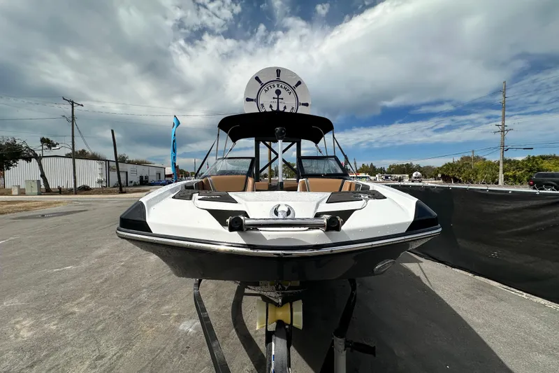 Slide: The Image of 2023 Scarab 215 ID boat on trailer under cloudy sky, front view. - 7