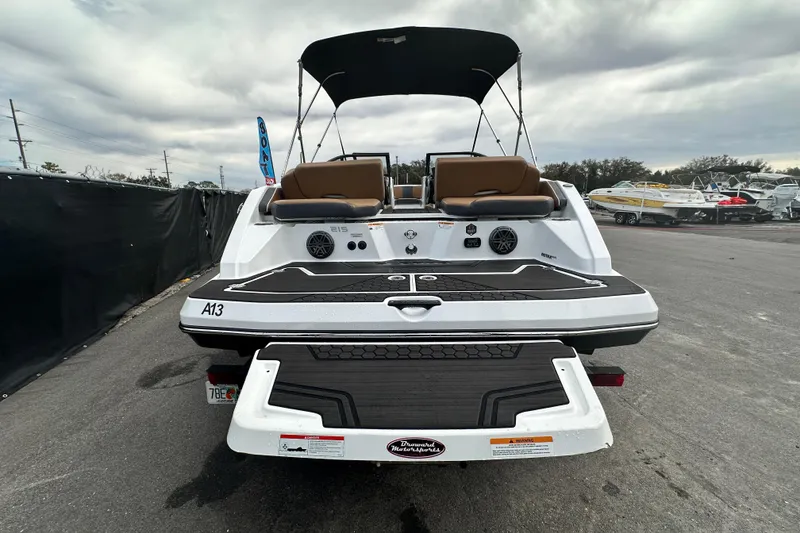 Slide: The Image of 2023 Scarab 215 ID boat, rear view, showcasing deck and seating under cloudy sky. - 9