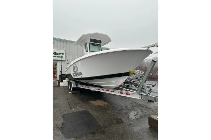 Slide: The Image of 2025 Wellcraft 263 Fisherman boat on trailer outside a building. - 1