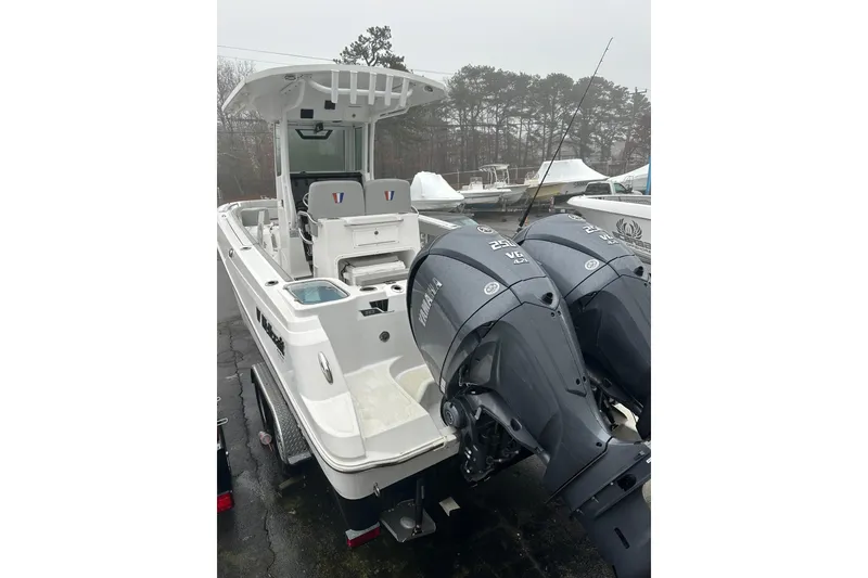 Slide: The Image of 2025 Wellcraft 263 Fisherman boat with dual Yamaha outboard engines, parked outdoors. - 2