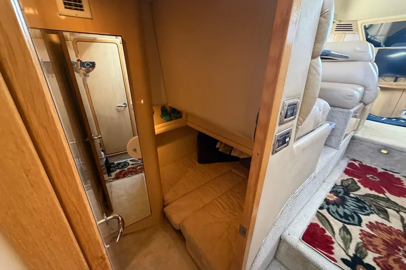 Slide: The Image of 2002 Sea Ray 480 Motor Yacht interior with cozy cabin and floral carpet. - 23