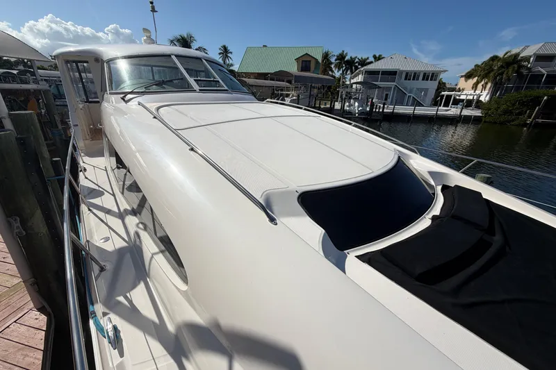 Slide: The Image of 2002 Sea Ray 480 Motor Yacht docked, showcasing sleek design and spacious deck. - 8