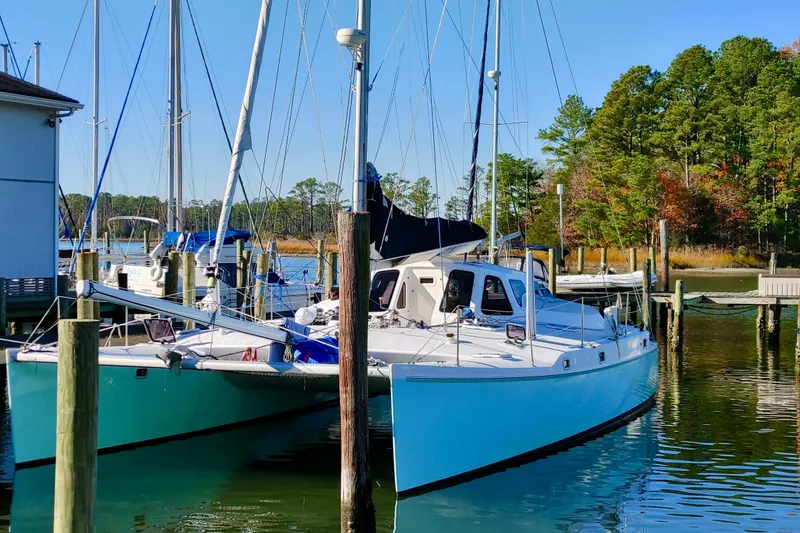 Slide: The Image of 2003 Chris White Atlantic 42 catamaran docked in a serene marina setting. - 1