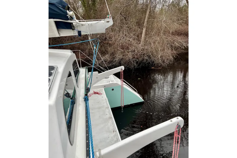 Slide: The Image of 2003 Chris White Atlantic 42 catamaran docked near wooded shoreline. - 11