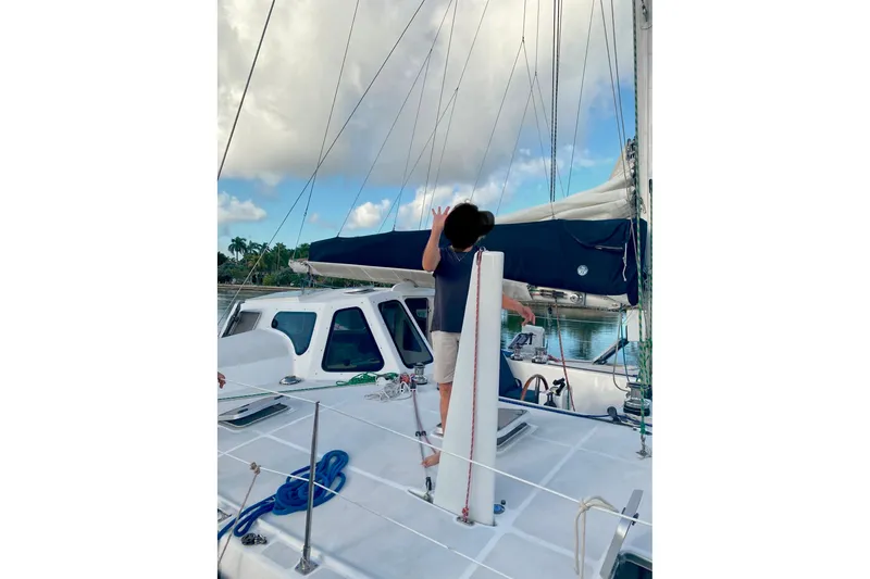 Slide: The Image of Person on deck of 2003 Chris White Atlantic 42 catamaran, with sails and clear sky. - 20