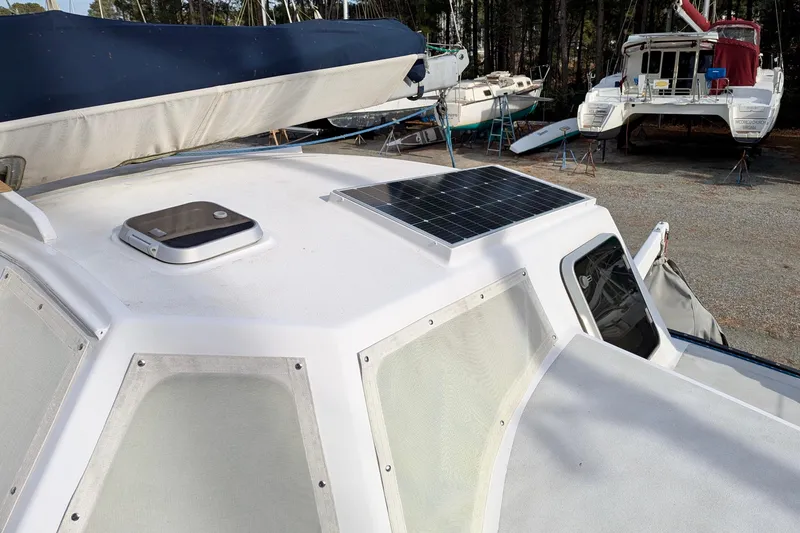 Slide: The Image of 2003 Chris White Atlantic 42 catamaran with solar panel on deck, docked in a boatyard. - 21
