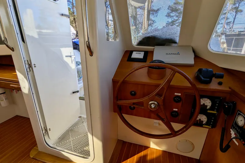 Slide: The Image of Interior helm of 2003 Chris White Atlantic 42 with wooden steering wheel and navigation equipment. - 38