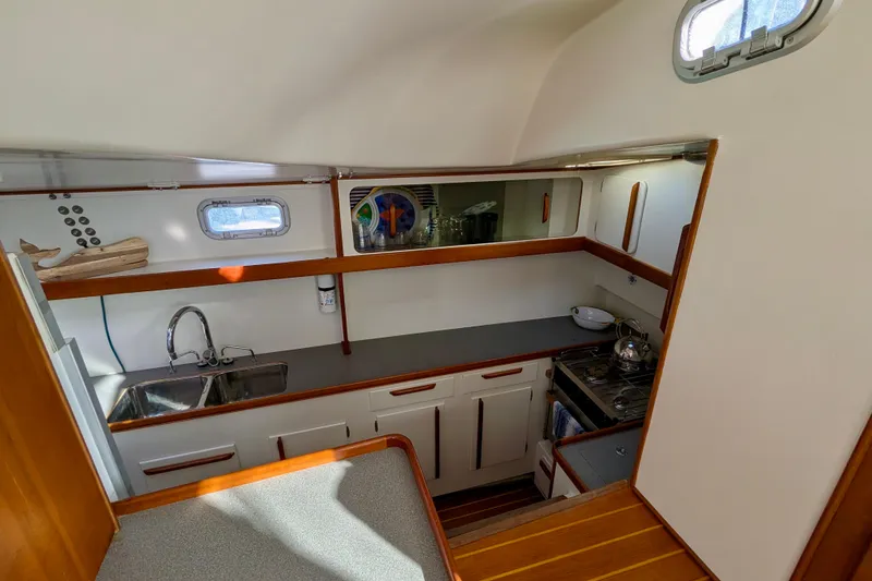 Slide: The Image of Interior of 2003 Chris White Atlantic 42 yacht, featuring a compact, well-equipped kitchen area. - 61