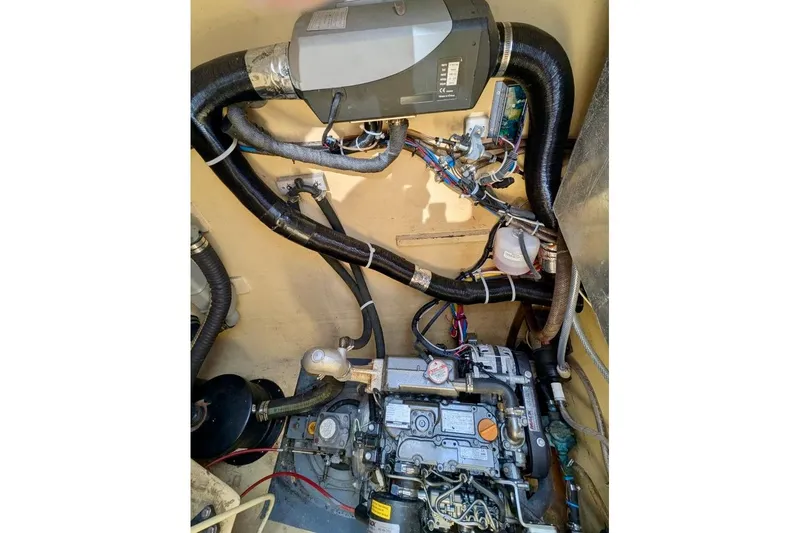 Slide: The Image of Engine compartment of 2003 Chris White Atlantic 42, showcasing mechanical components and wiring. - 83