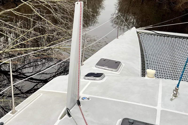 Slide: The Image of Deck of 2003 Chris White Atlantic 42 catamaran with netting and river view. - 9
