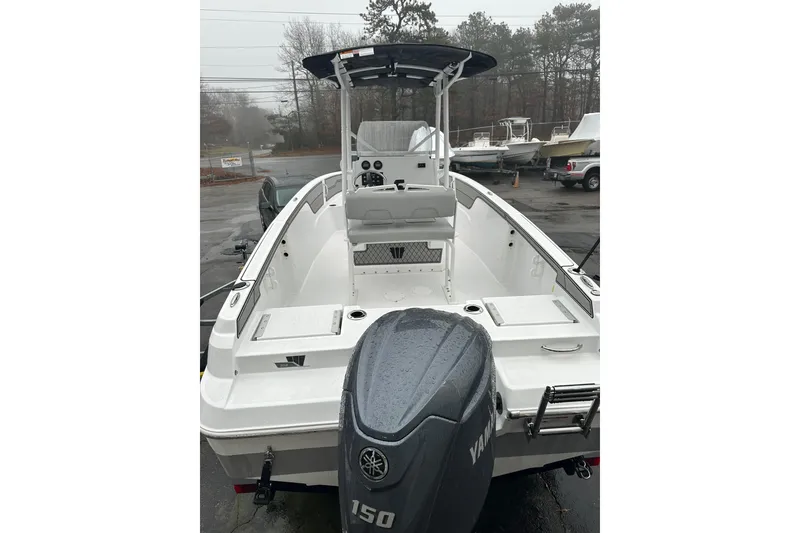 Slide: The Image of 2025 Wellcraft 202 Fisherman boat with Yamaha engine, parked outdoors on a rainy day. - 1
