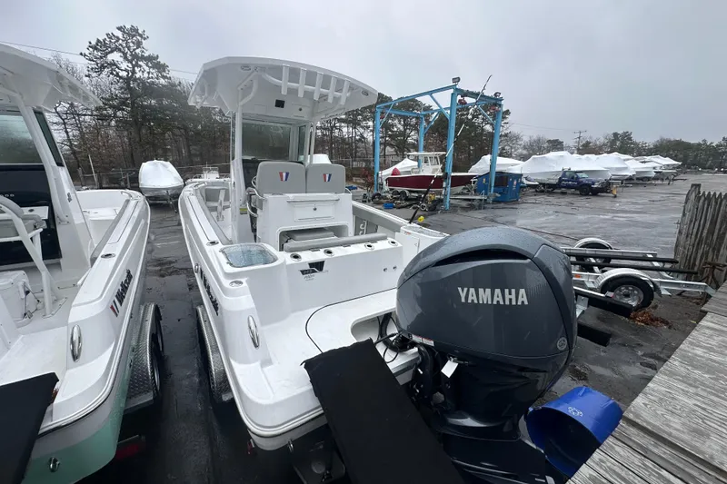 Slide: The Image of 2025 Wellcraft 243 Fisherman boat with Yamaha engine in a marina setting. - 2
