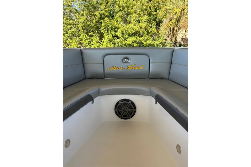 Slide: The Image of 2017 Nor-Tech 390 Sport Center Console boat interior with cushioned seating and speaker. - 10