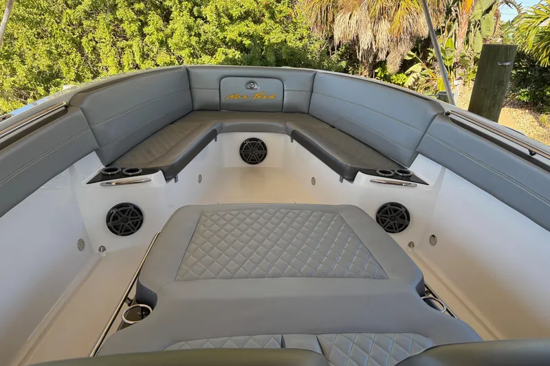 Slide: The Image of 2017 Nor-Tech 390 Sport Center Console boat interior with gray seating and speakers. - 11