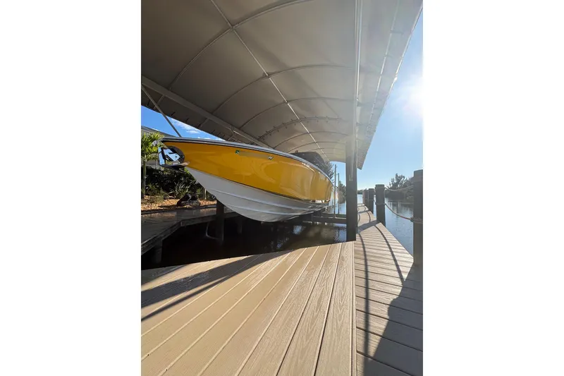 Slide: The Image of 2017 Nor-Tech 390 Sport Center Console in yellow, docked under a canopy. - 2