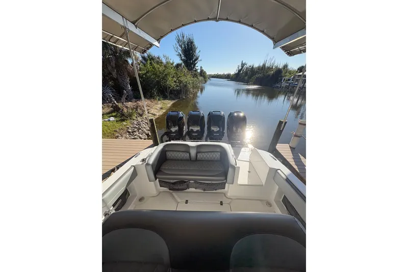Slide: The Image of 2017 Nor-Tech 390 Sport Center Console boat docked by a serene river. - 24
