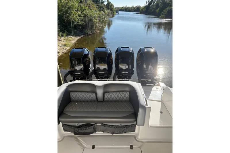 Slide: The Image of 2017 Nor-Tech 390 Sport Center Console with quad engines on a serene waterway. - 25