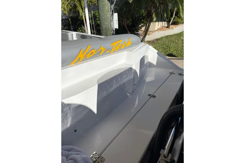 Slide: The Image of 2017 Nor-Tech 390 Sport Center Console boat with logo, docked near greenery. - 26