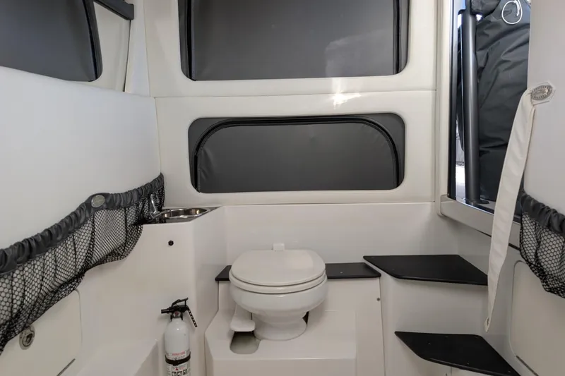 Slide: The Image of 2017 Nor-Tech 390 Sport Center Console boat interior with toilet and storage compartments. - 27