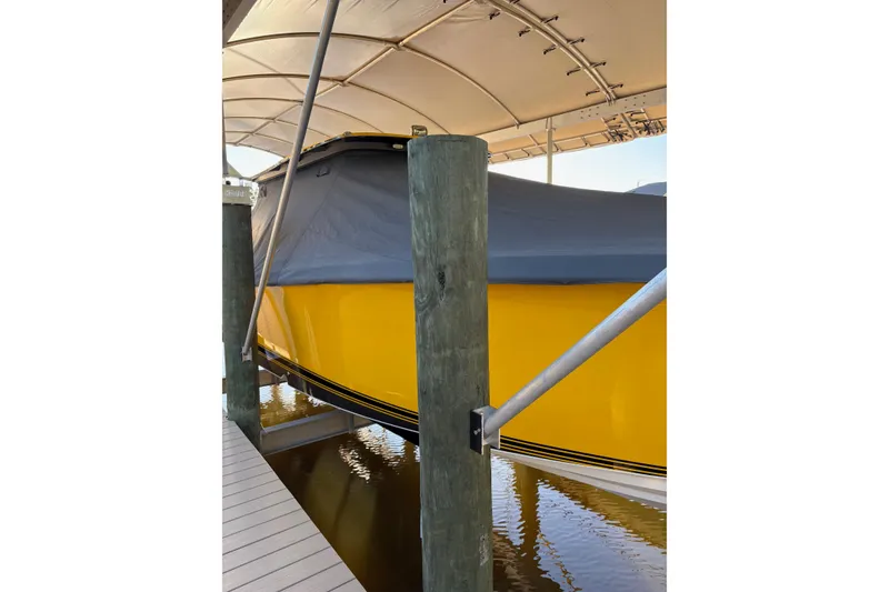 Slide: The Image of 2017 Nor-Tech 390 Sport Center Console, yellow hull, covered, docked under canopy. - 4