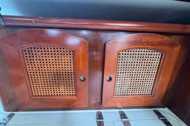 Slide: The Image of Wooden cabinet with woven rattan doors inside a 1996 Beneteau 50 yacht. - 102