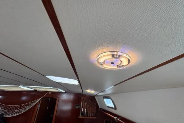 Slide: The Image of Interior of 1996 Beneteau 50 yacht, featuring ceiling light and wooden accents. - 104