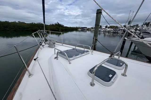 Slide: The Image of Deck view of a 1996 Beneteau 50 sailboat docked by calm waters. - 21