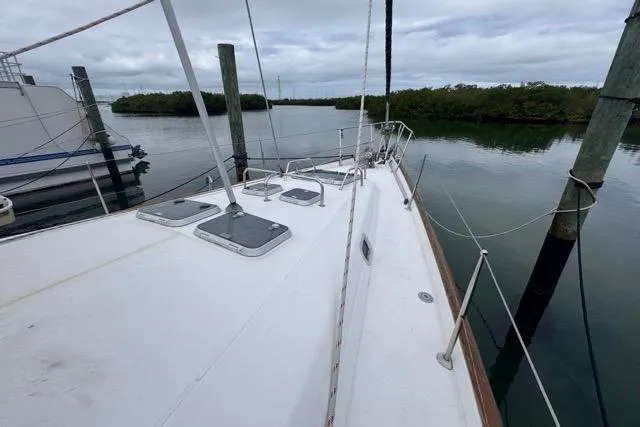 Slide: The Image of Sailboat deck view of 1996 Beneteau 50, docked in calm waters. - 29